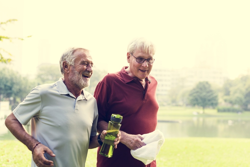 a couple of men smiling and holding a bottle of beer